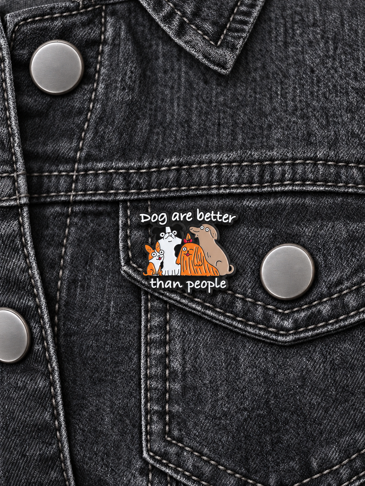 Dogs Are Better Than People Pin displayed on a charcoal denim jacket beside a metal button