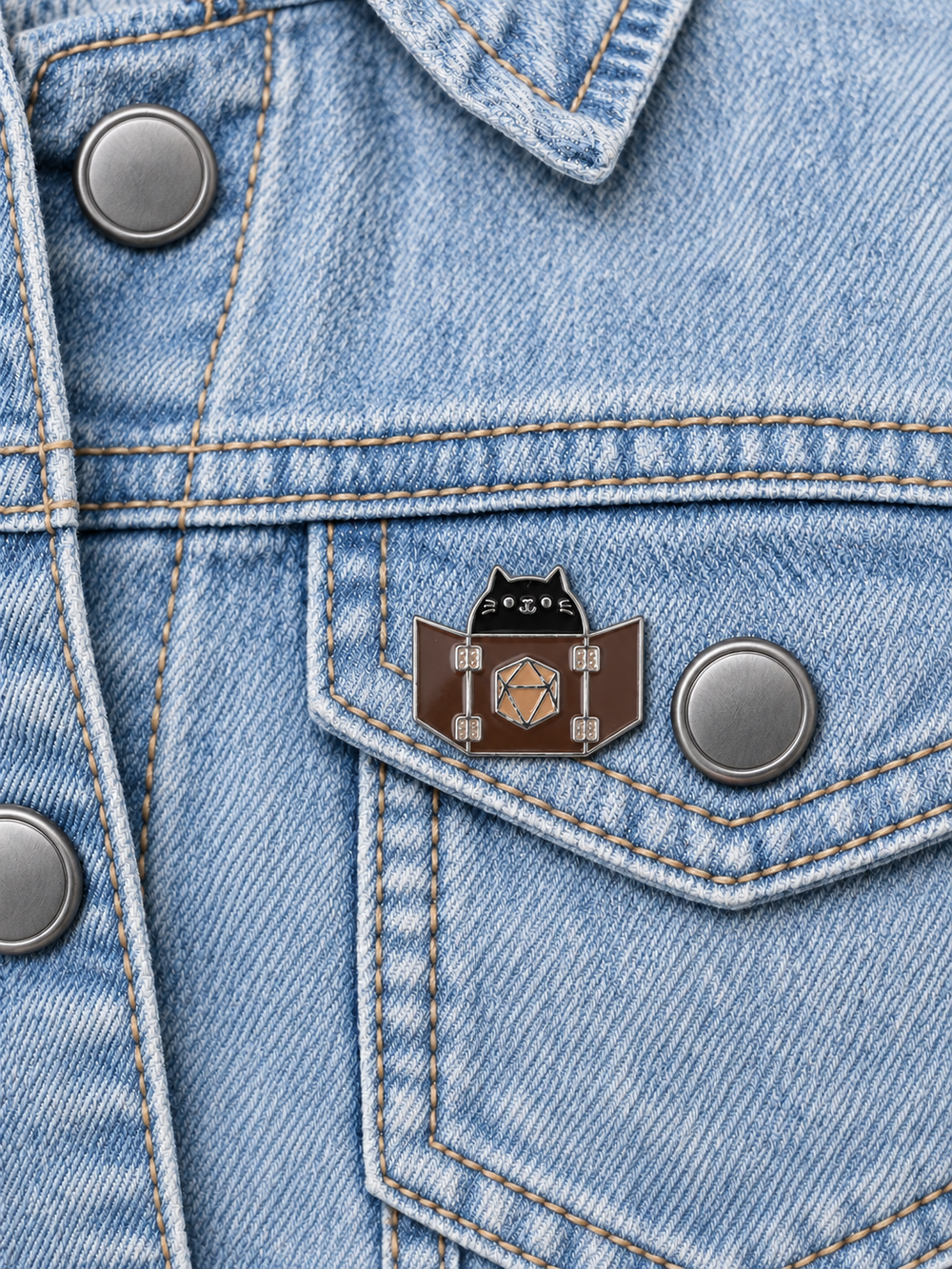 Dungeon Master Cat Pin displayed on light-wash denim beside a metal button
