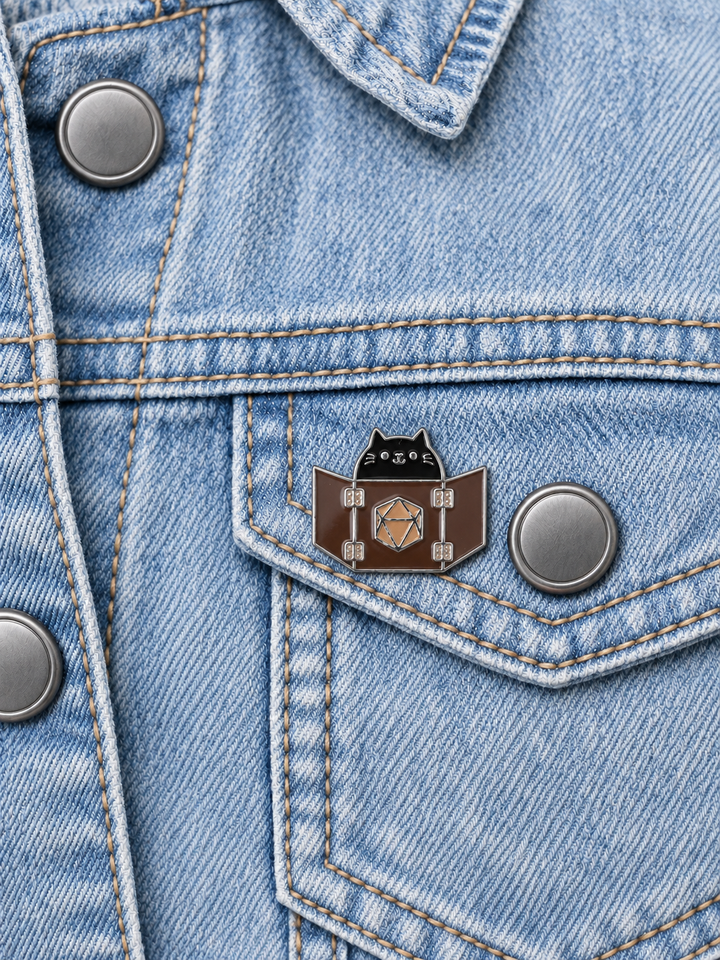 Dungeon Master Cat Pin displayed on light-wash denim beside a metal button