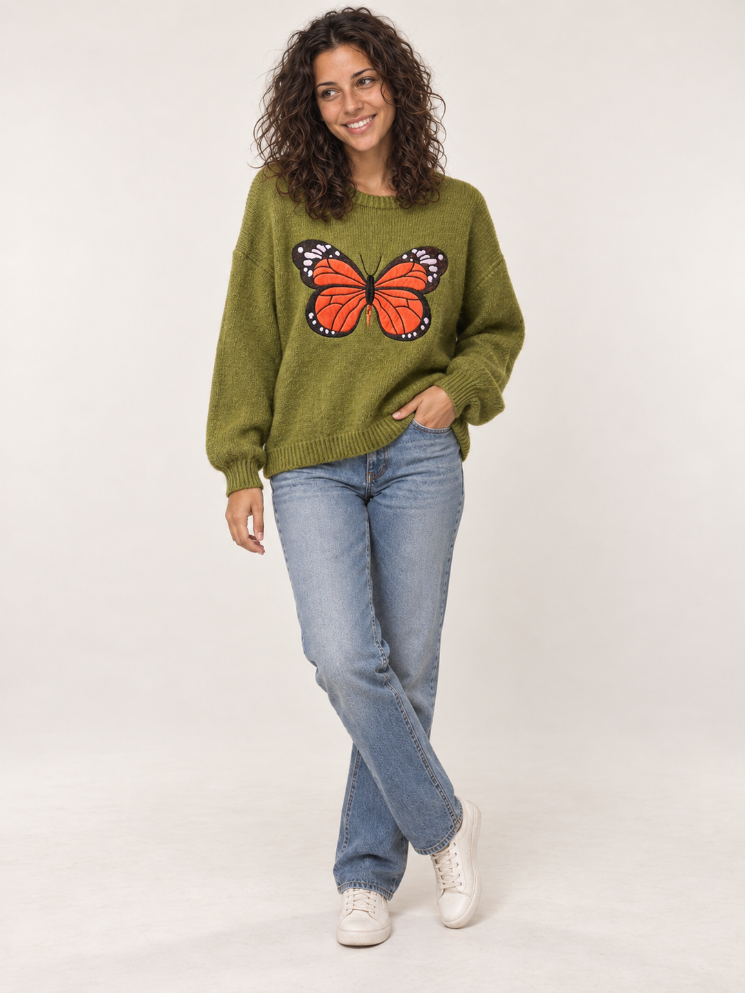 Full body view of model wearing green embroidered monarch butterfly sweater