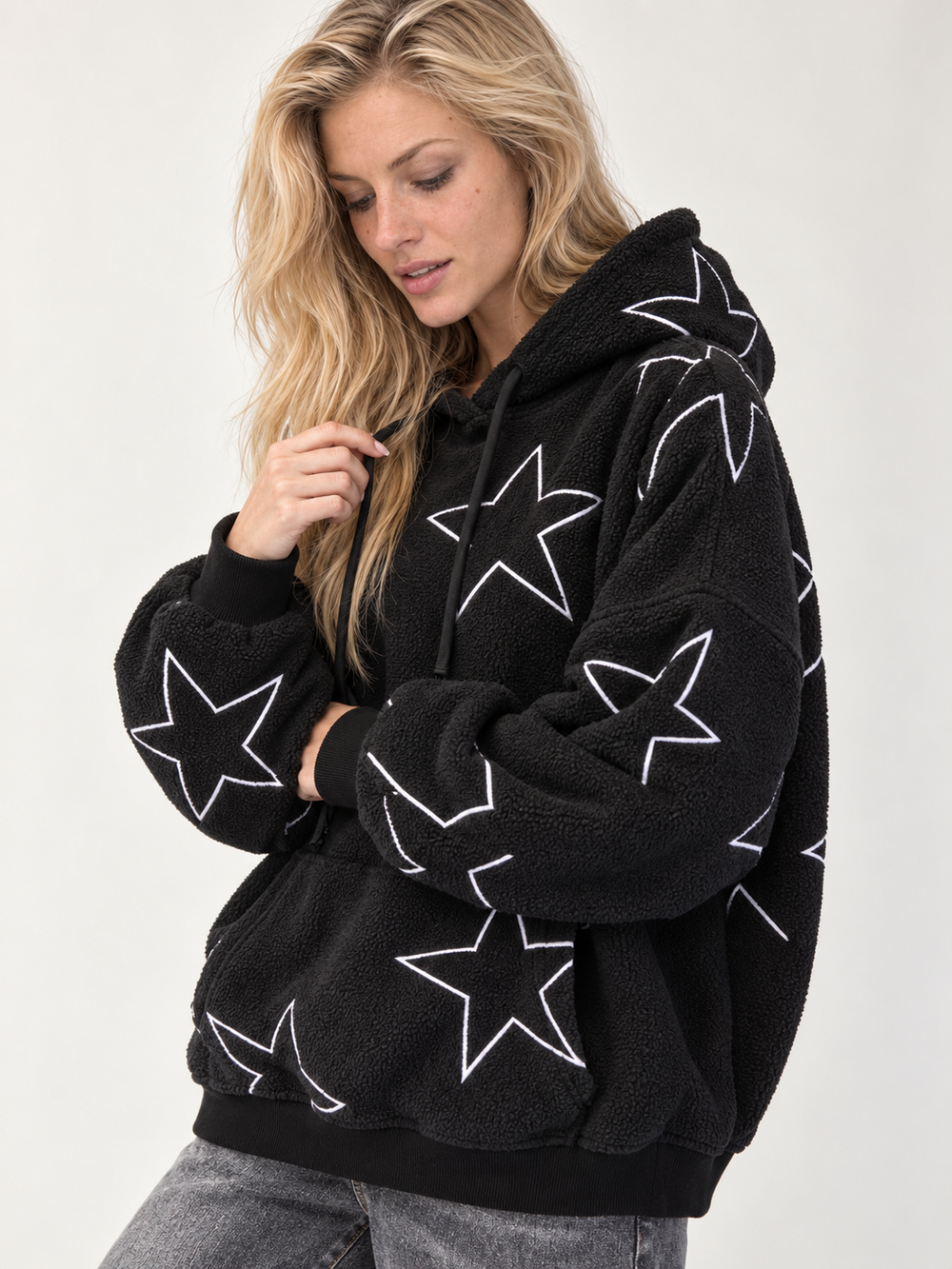 Model wearing the Embroidered Star Sherpa Hoodie Black — angled view
