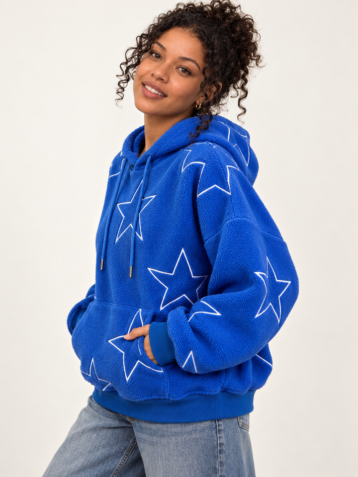 Model wearing Embroidered Star Sherpa Hoodie Blue, angled view