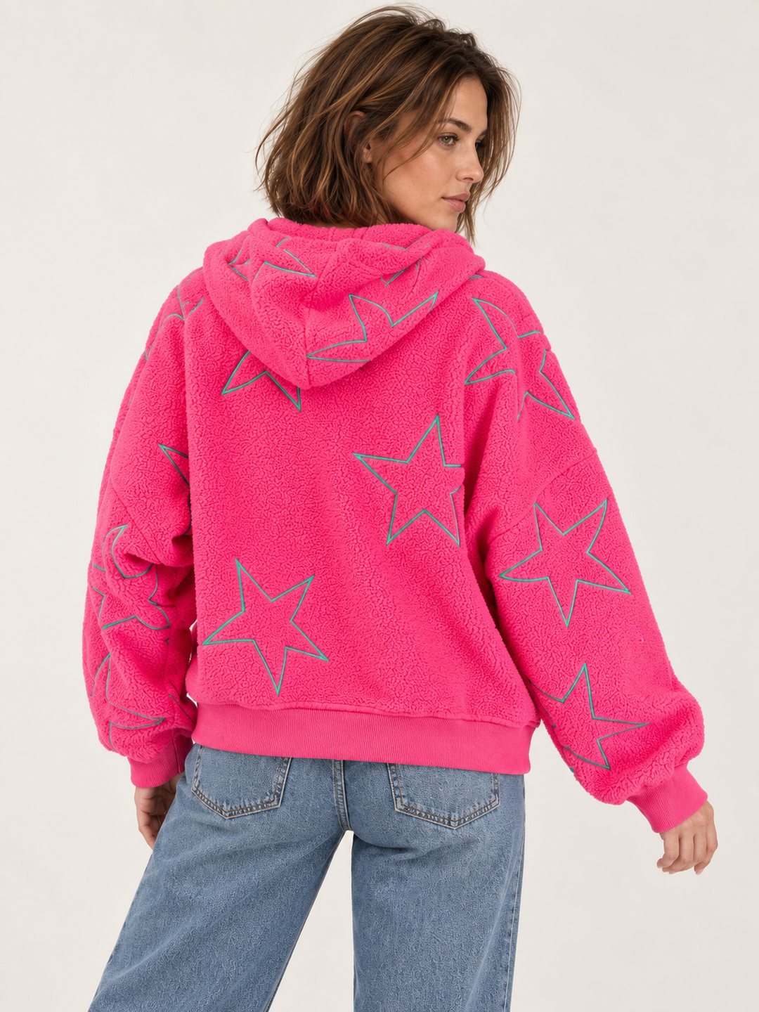 Model wearing embroidered star sherpa hoodie in pink, back view