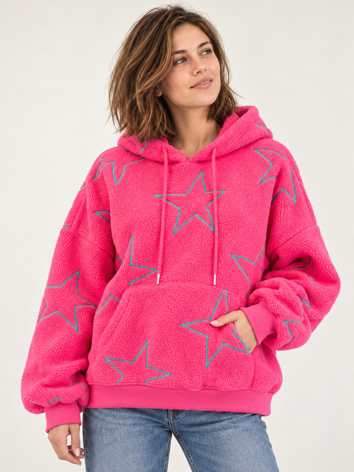 Model wearing embroidered star sherpa hoodie in pink, front view