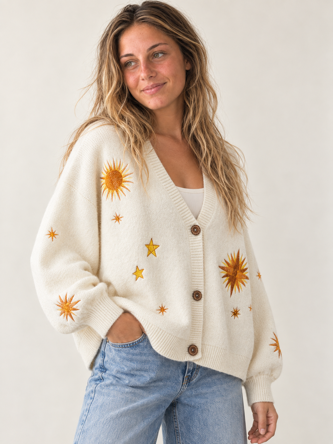 Model wearing oversized ivory embroidered sunburst and star cardigan, three-quarter view