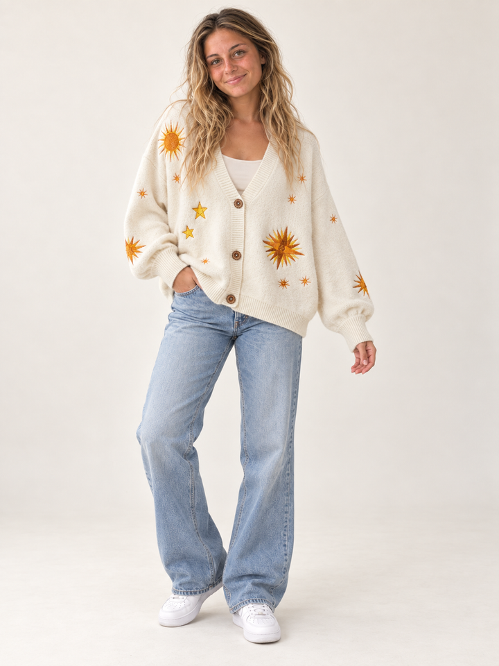 Model wearing oversized ivory embroidered sunburst and star cardigan, full-body view
