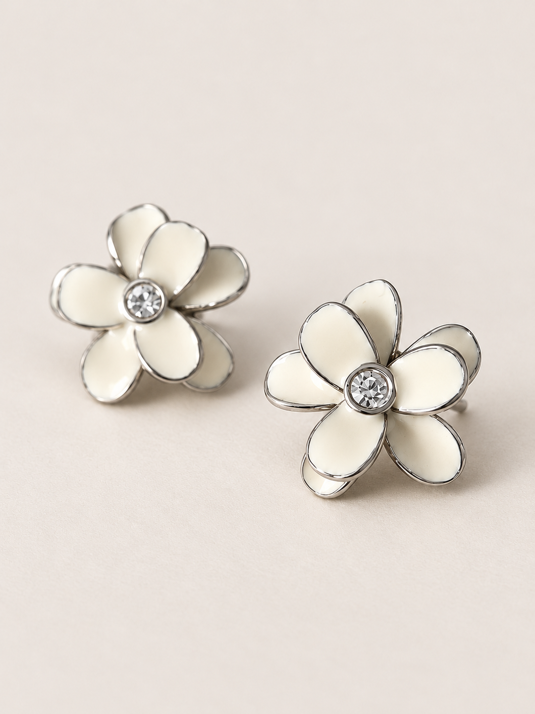 Enamel Flower Stud Earrings white angle on a warm neutral background