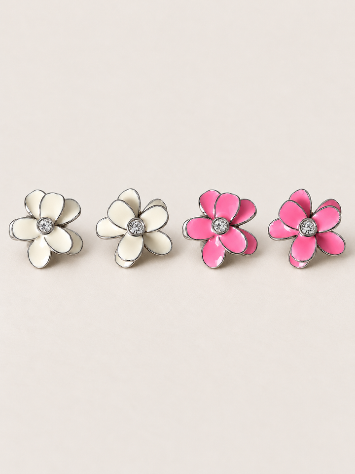 Enamel Flower Stud Earrings in White and Pink, both sterling silver, on a warm neutral background