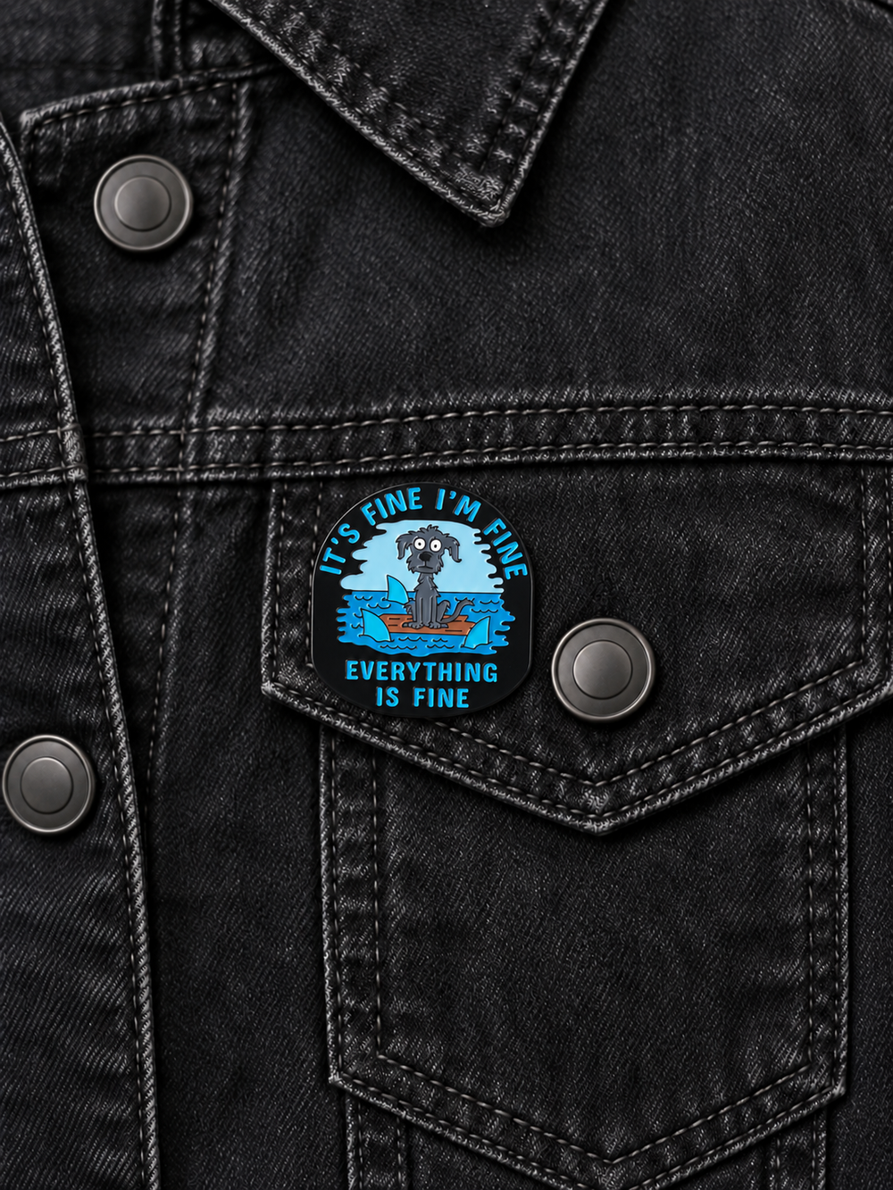 Everything Is Fine Dog Pin displayed on a black denim jacket beside a metal button
