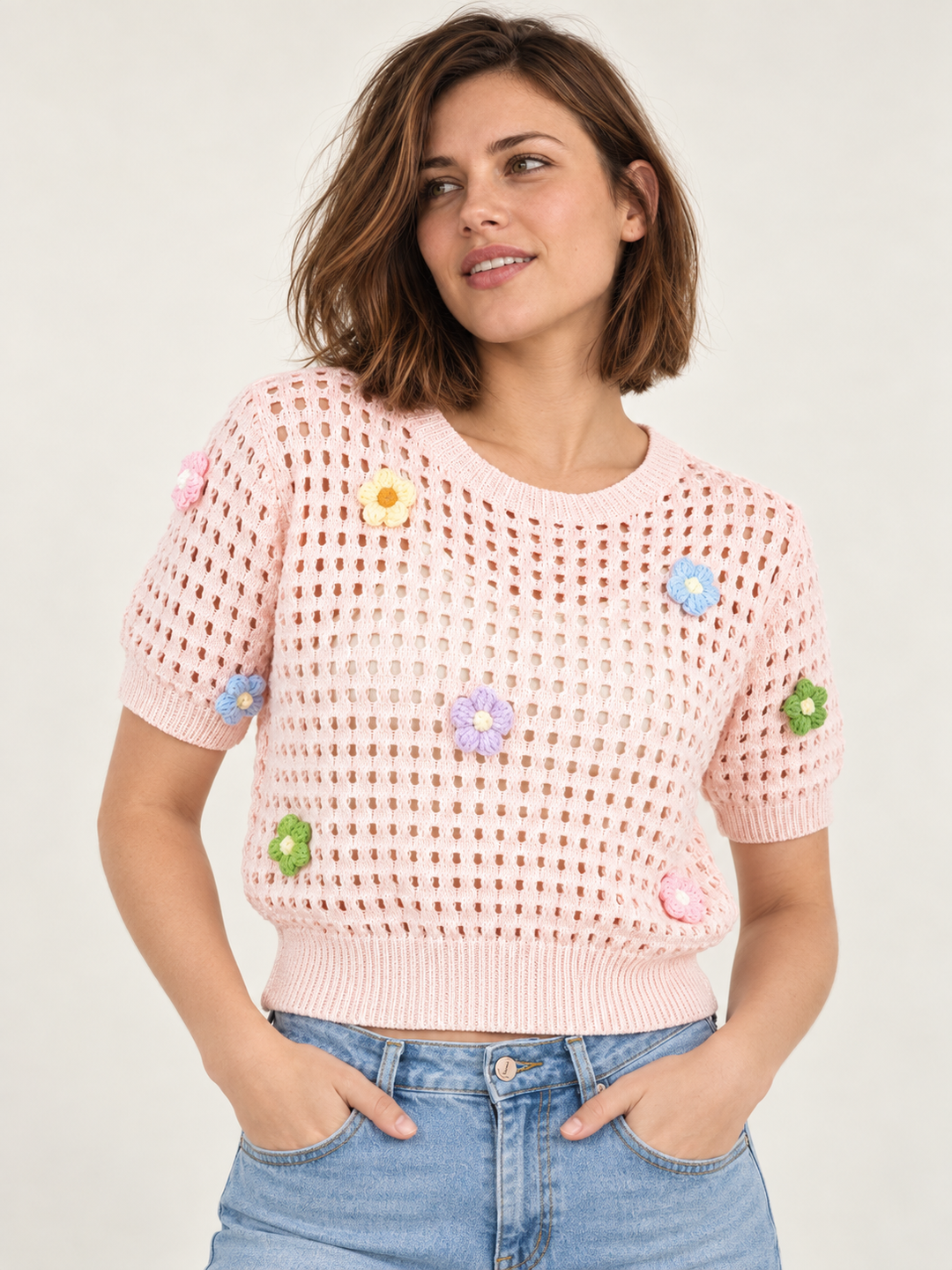 Model wearing Flower Open Knit Short Sleeve Top Pink over an ivory scoop-neck tank, front view