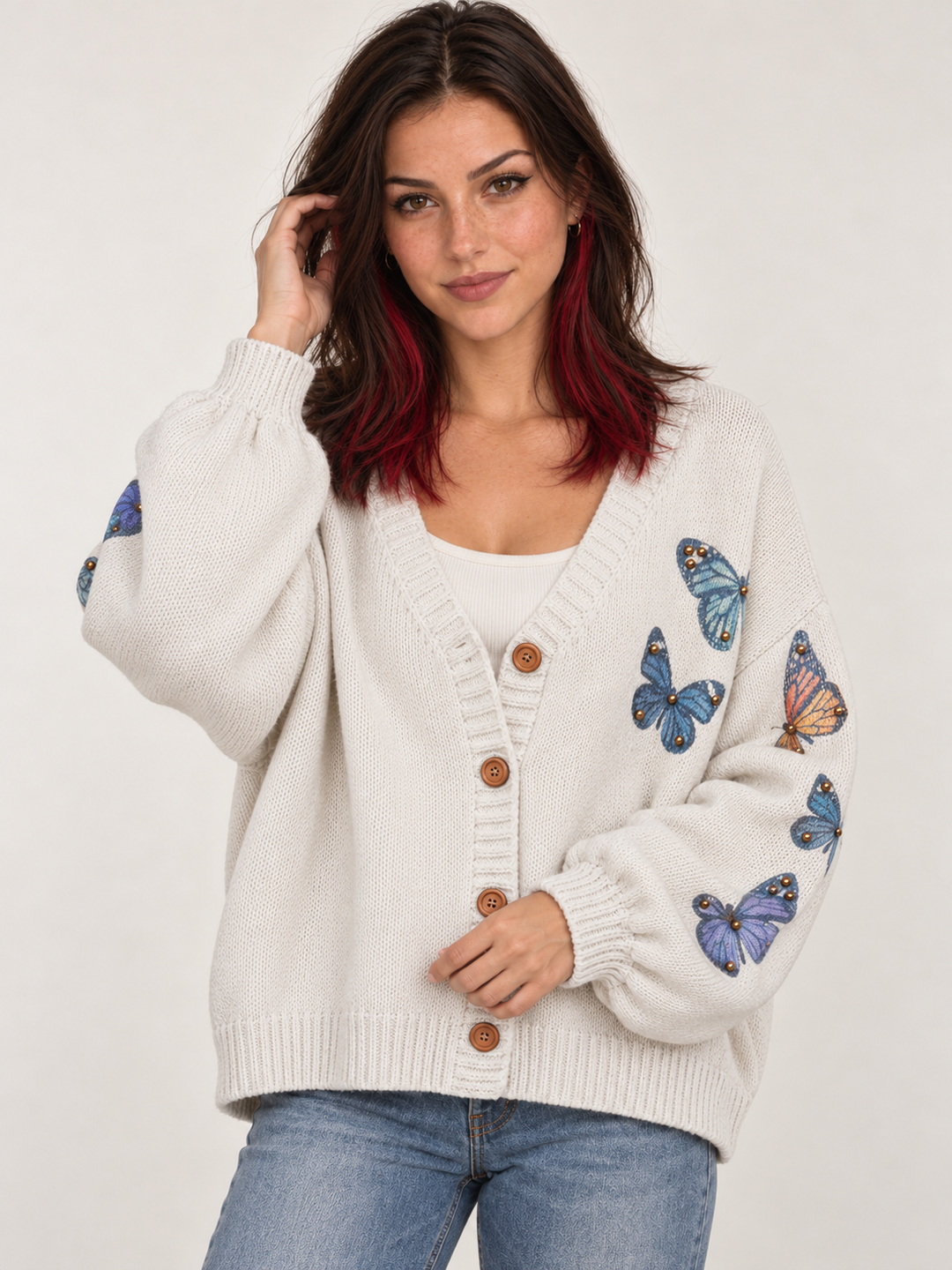 Front view of model wearing oversized ivory butterfly cardigan with gold-tone studs