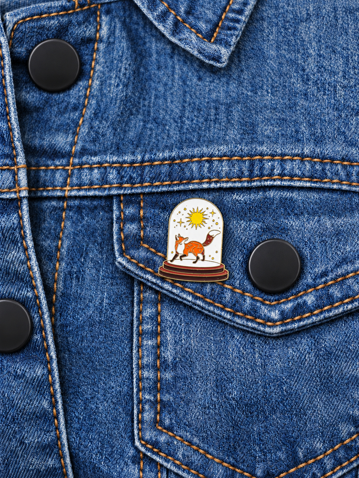 Fox Sun Glass Dome Pin displayed on a medium-blue denim jacket beside a black button