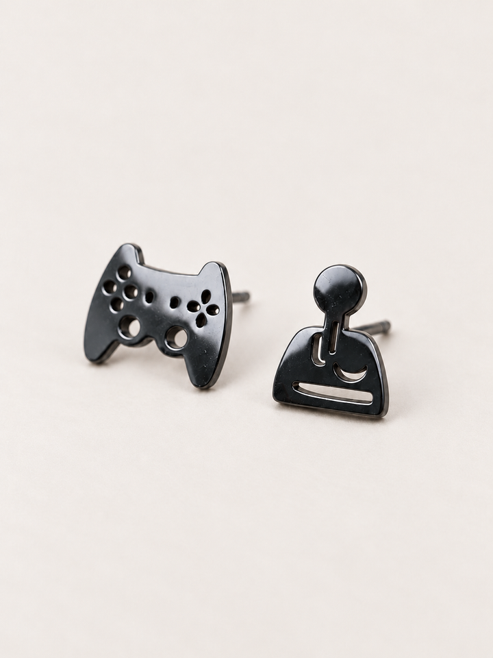 black Game Controller and Joystick Earrings shown angled on a warm neutral background