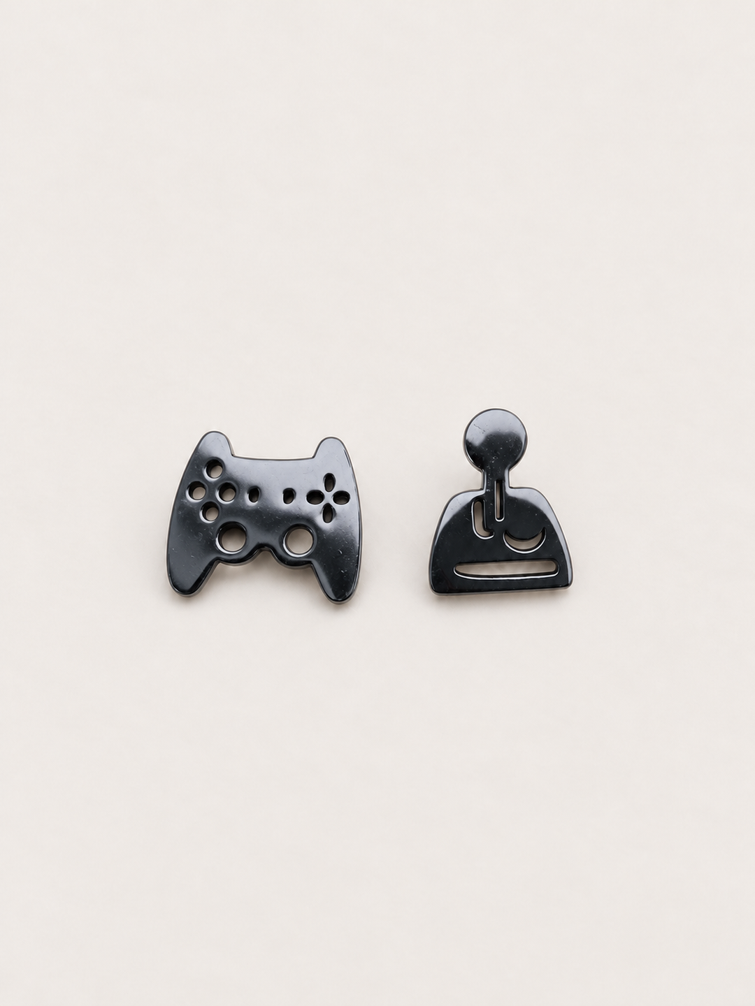 black Game Controller and Joystick Earrings shown on a warm neutral background