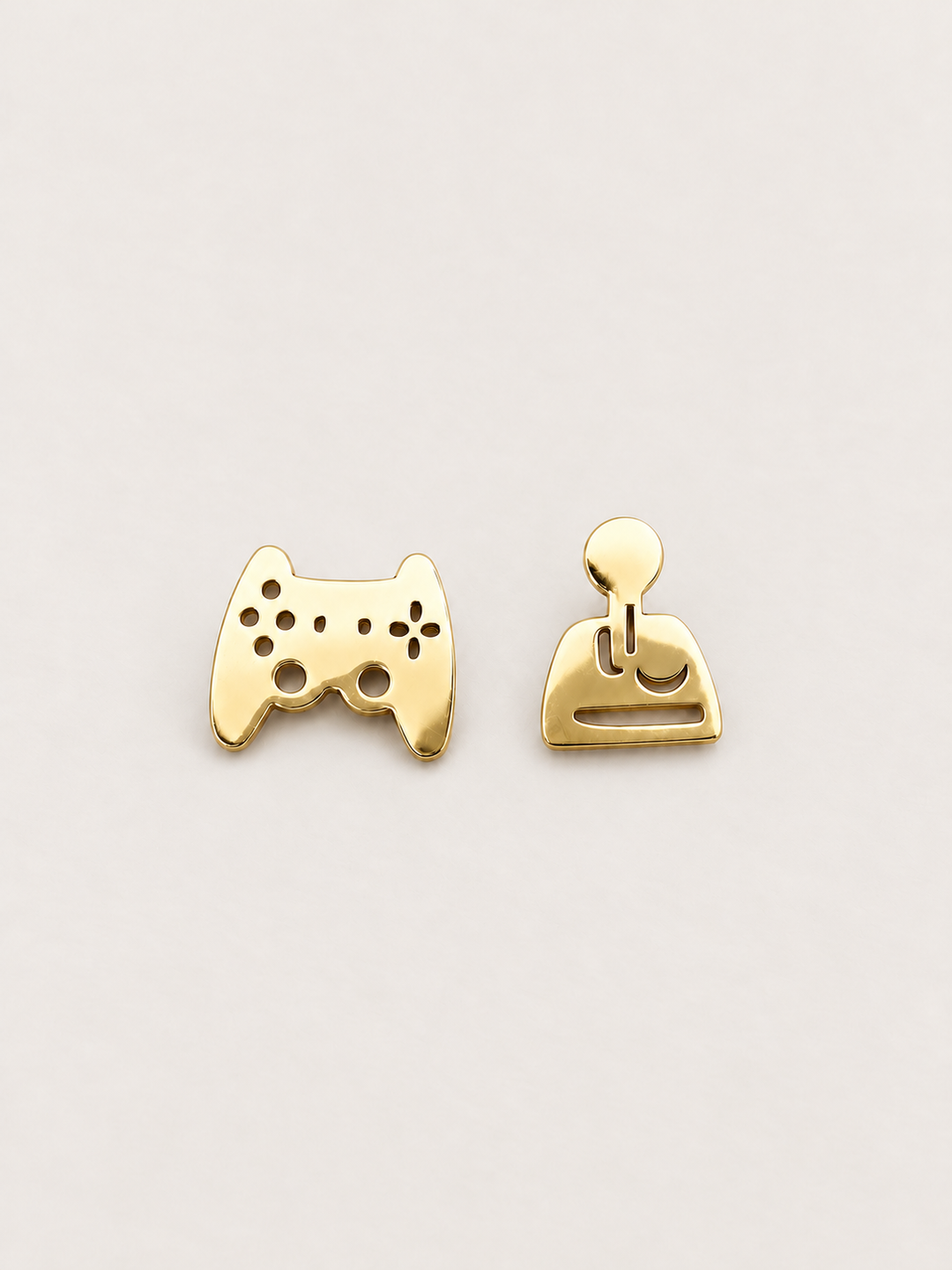 gold Game Controller and Joystick Earrings shown on a warm neutral background