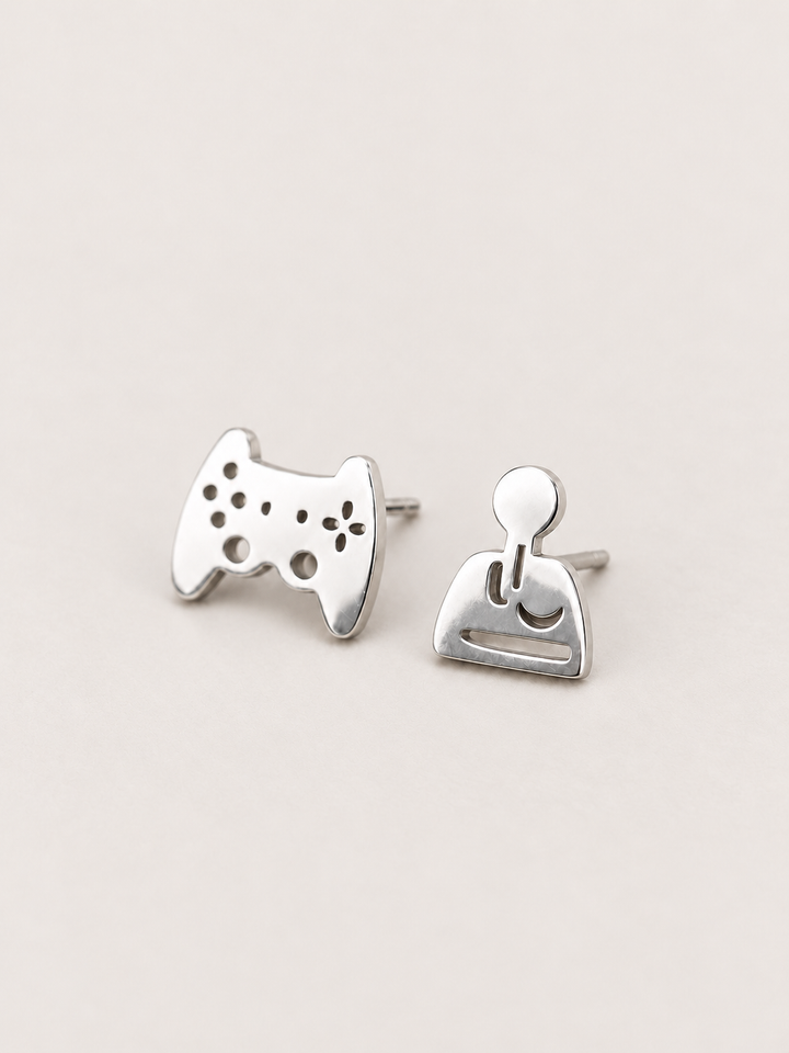 silver Game Controller and Joystick Earrings shown angled on a warm neutral background