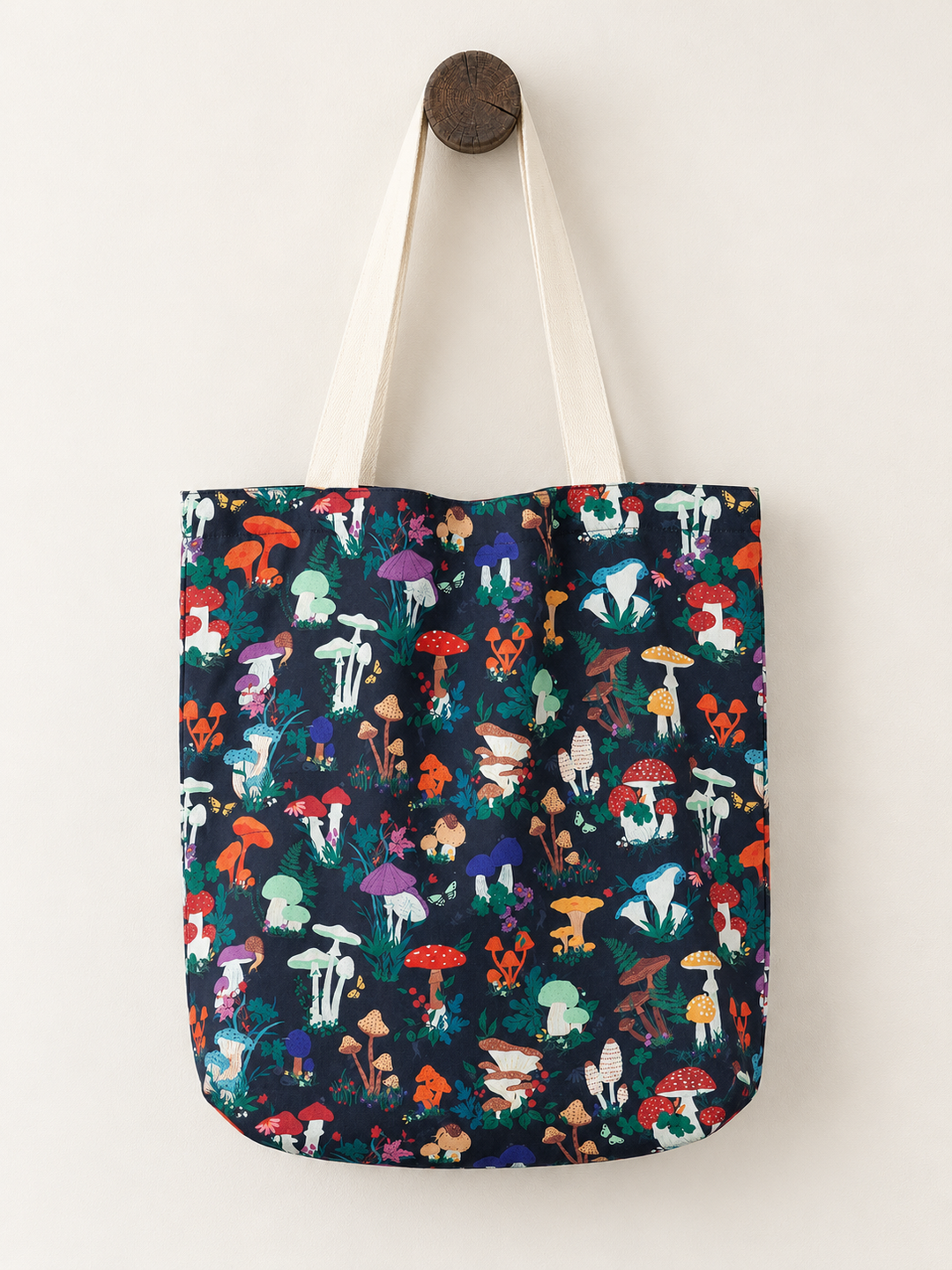 Garden Mushroom Tote Bag hanging on a wooden post