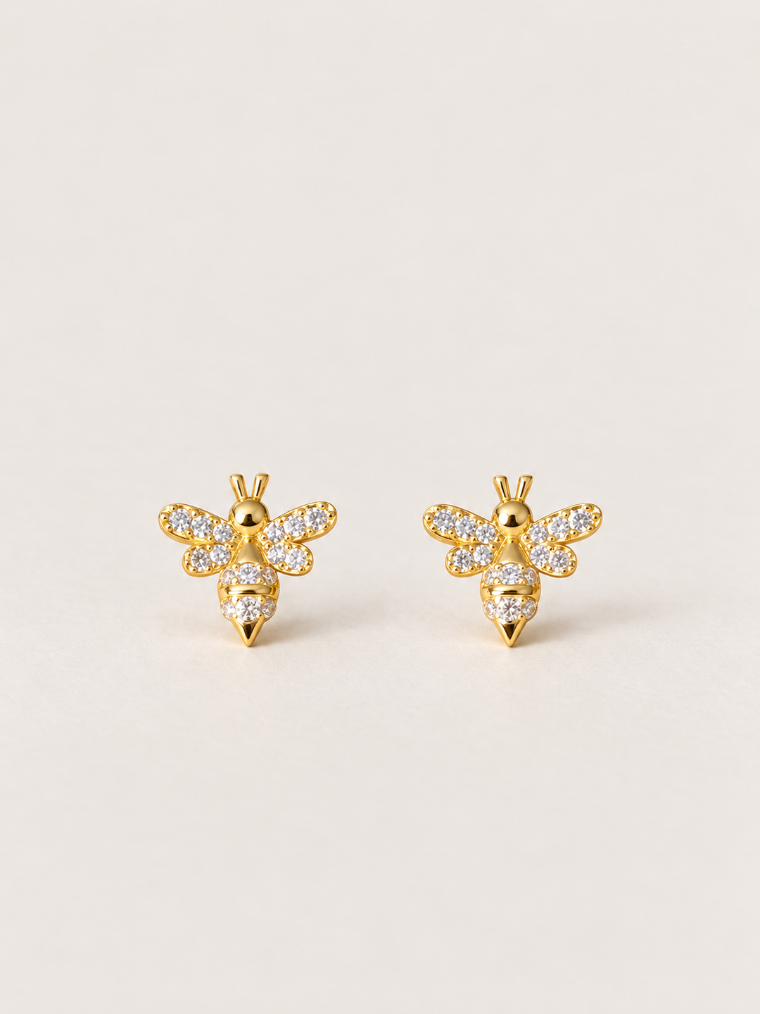 Gold Crystal Bee Stud Earrings shown on a warm neutral background