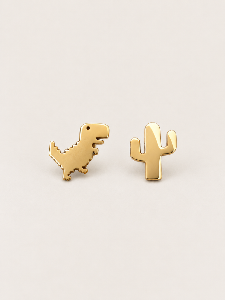 Gold Dinosaur and Cactus Stud Earrings shown on a warm neutral background