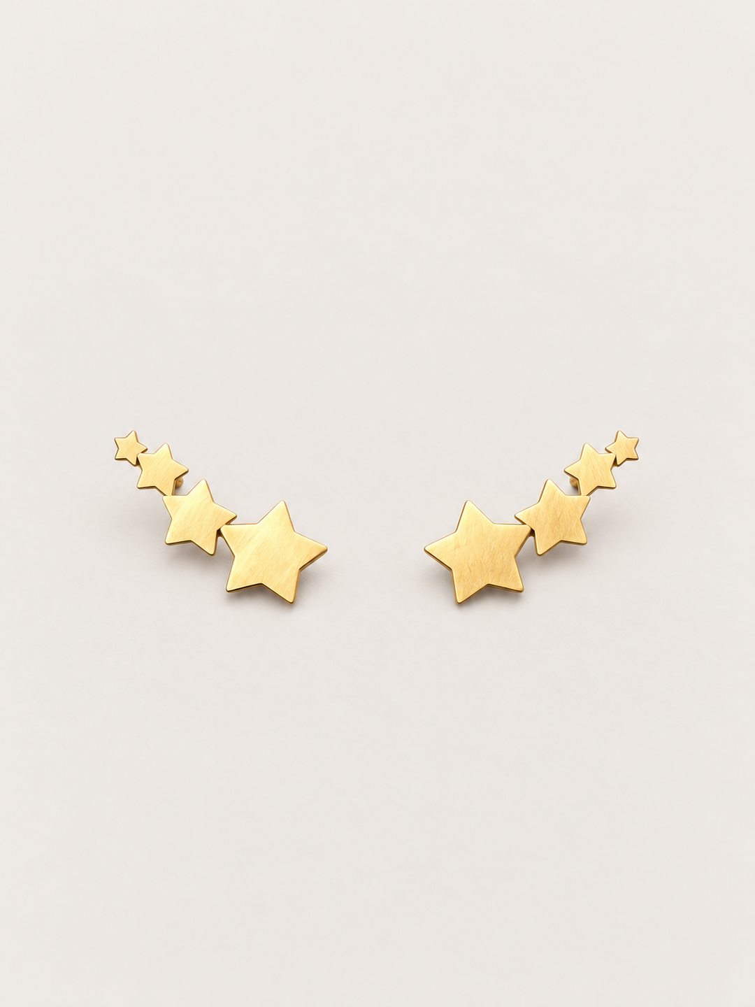 Gold Graduated Star Stud Earrings shown on a warm neutral background