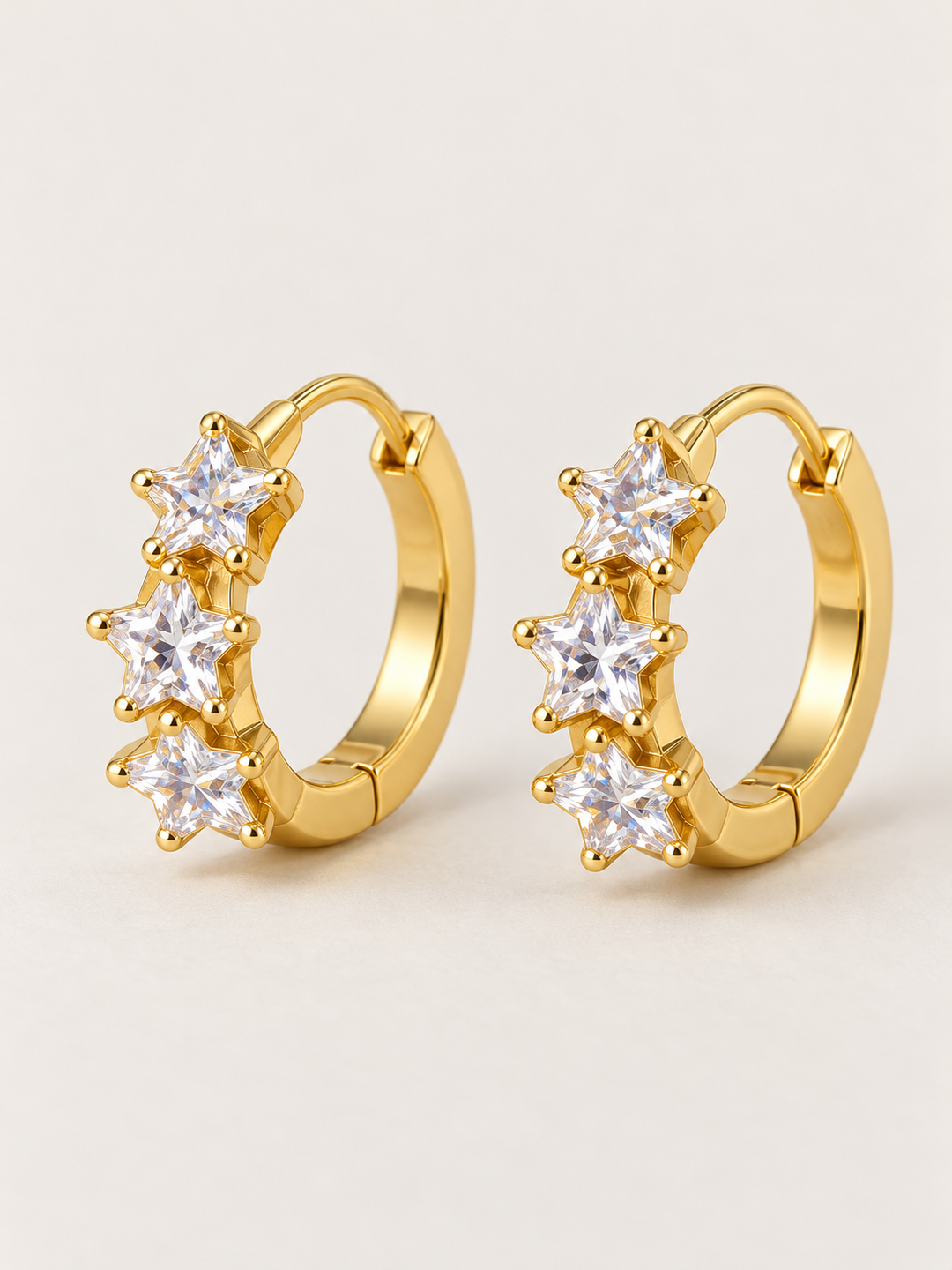 Gold Huggie Earrings shown on a warm neutral background