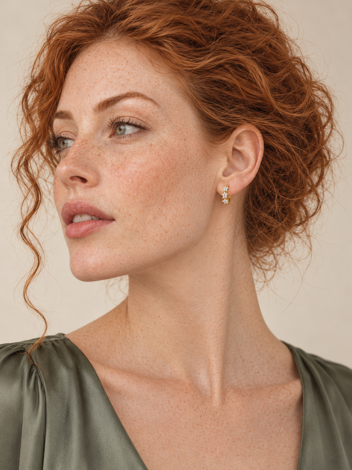 Model wearing Gold Huggie Earrings with three star-shaped gemstones