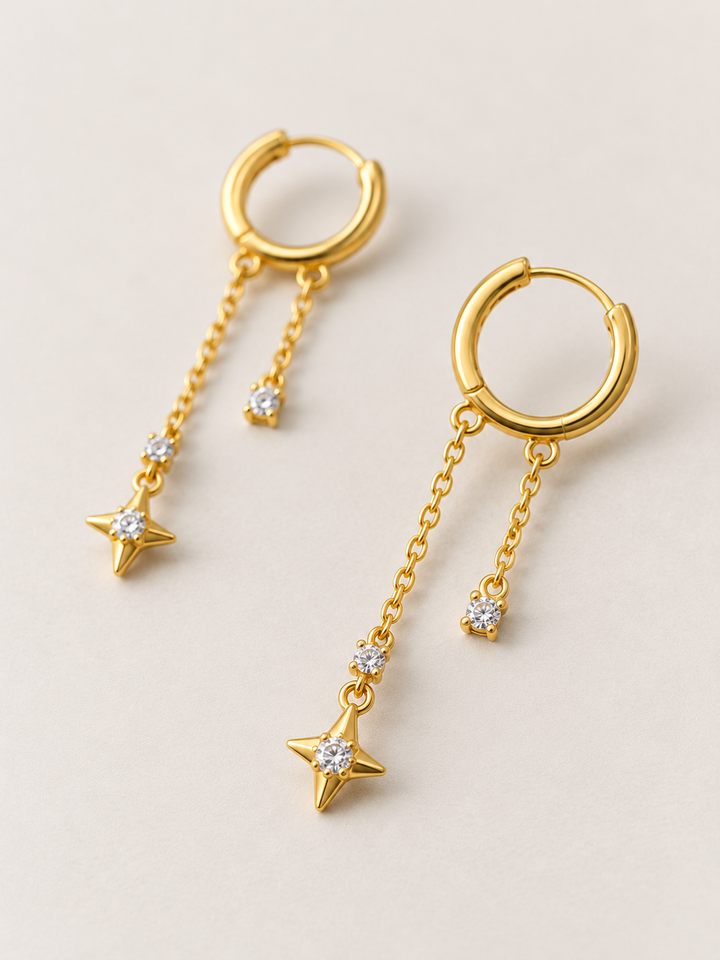 Gold Star Chain Hoop Earrings shown angled on a warm neutral background