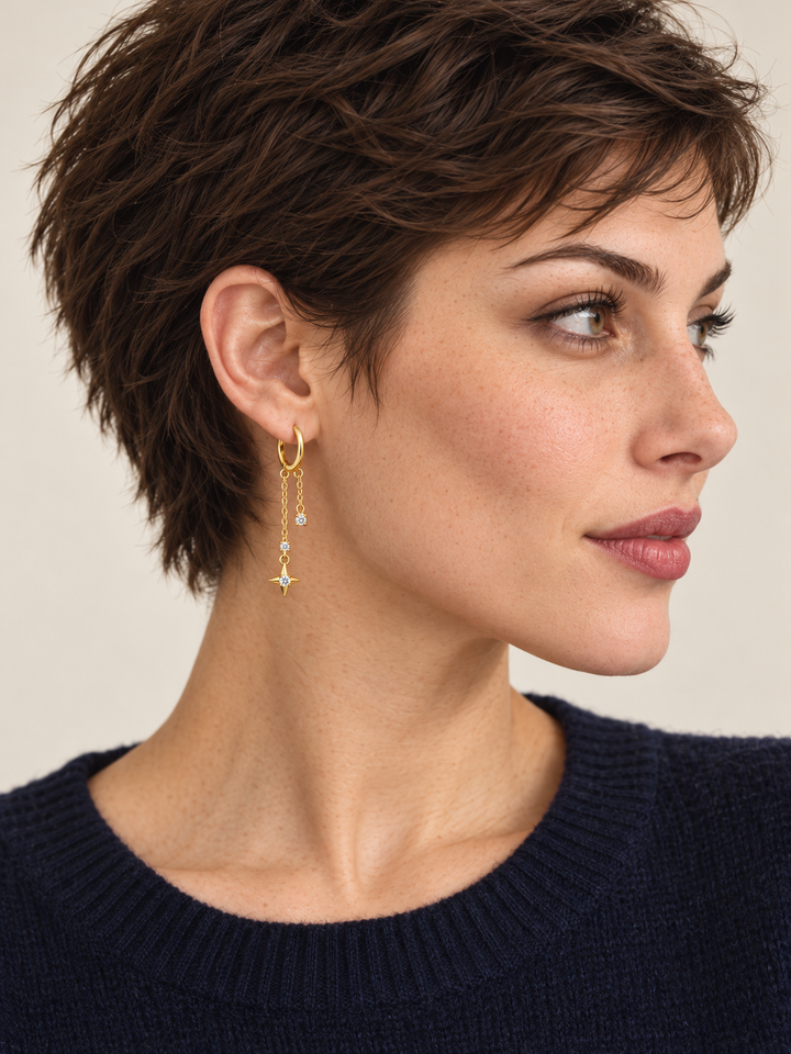 Gold Star Chain Hoop Earrings worn on the viewer-left ear