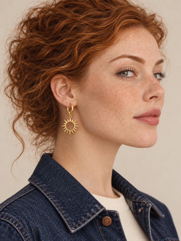 Gold sun hoop earring worn on the viewer-left ear