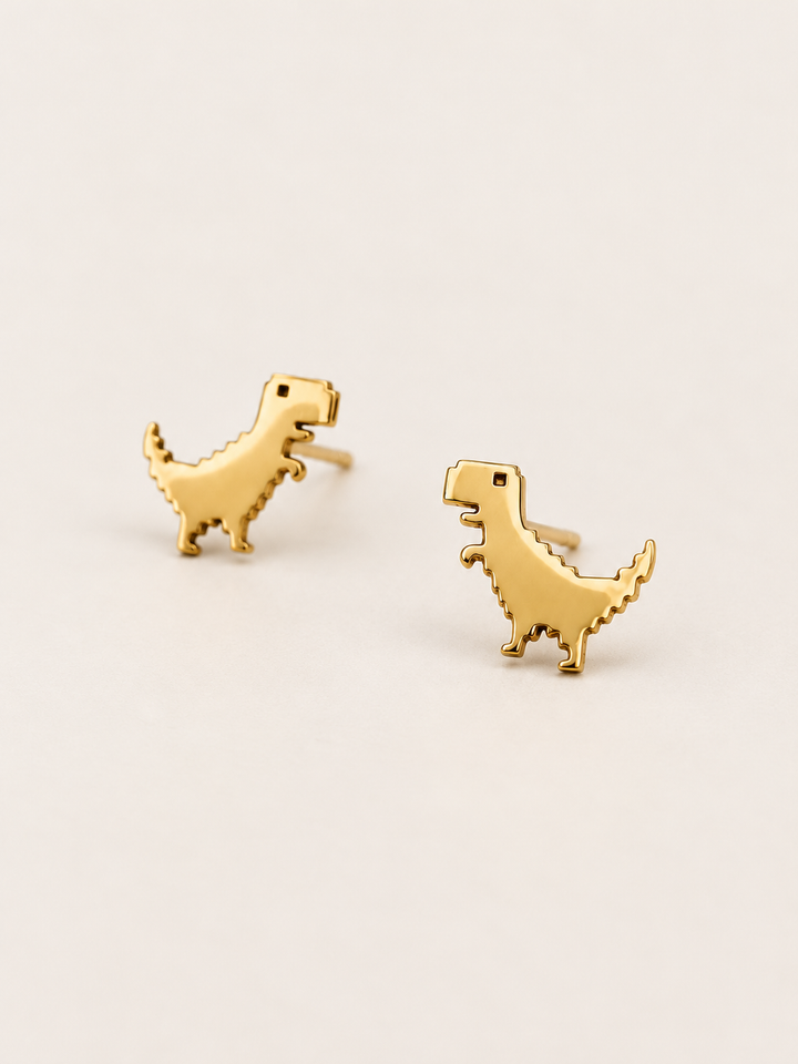 Gold T-Rex Stud Earrings shown angled on a warm neutral background