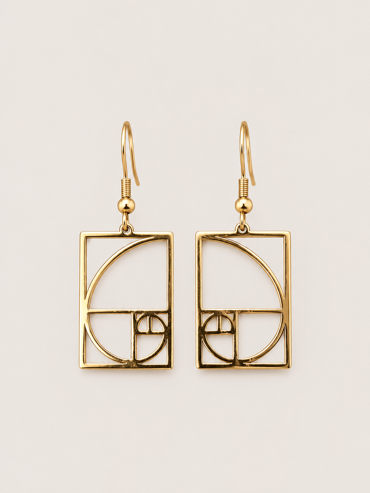 Gold Golden Ratio Spiral Drop Earrings shown on a warm neutral background