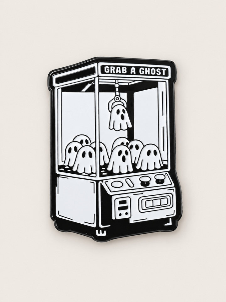 Grab a Ghost Claw Machine Pin shown on a warm neutral background