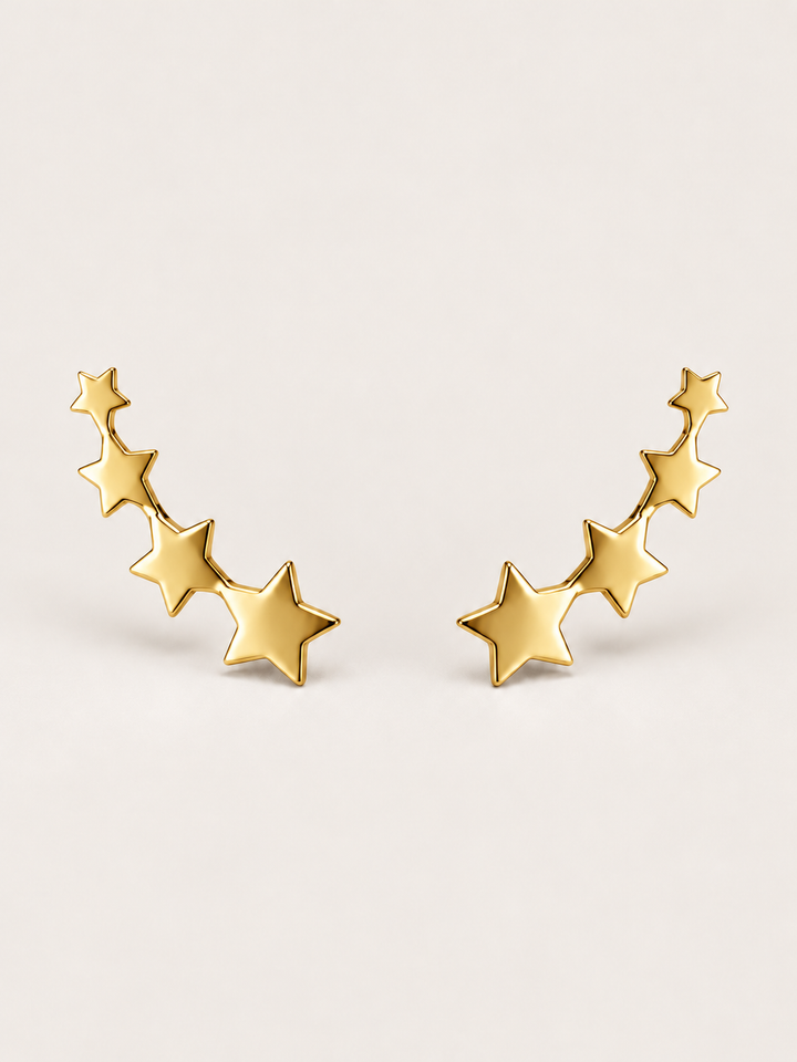 Gold Graduated Star Ear Crawler Earrings shown on a warm neutral background