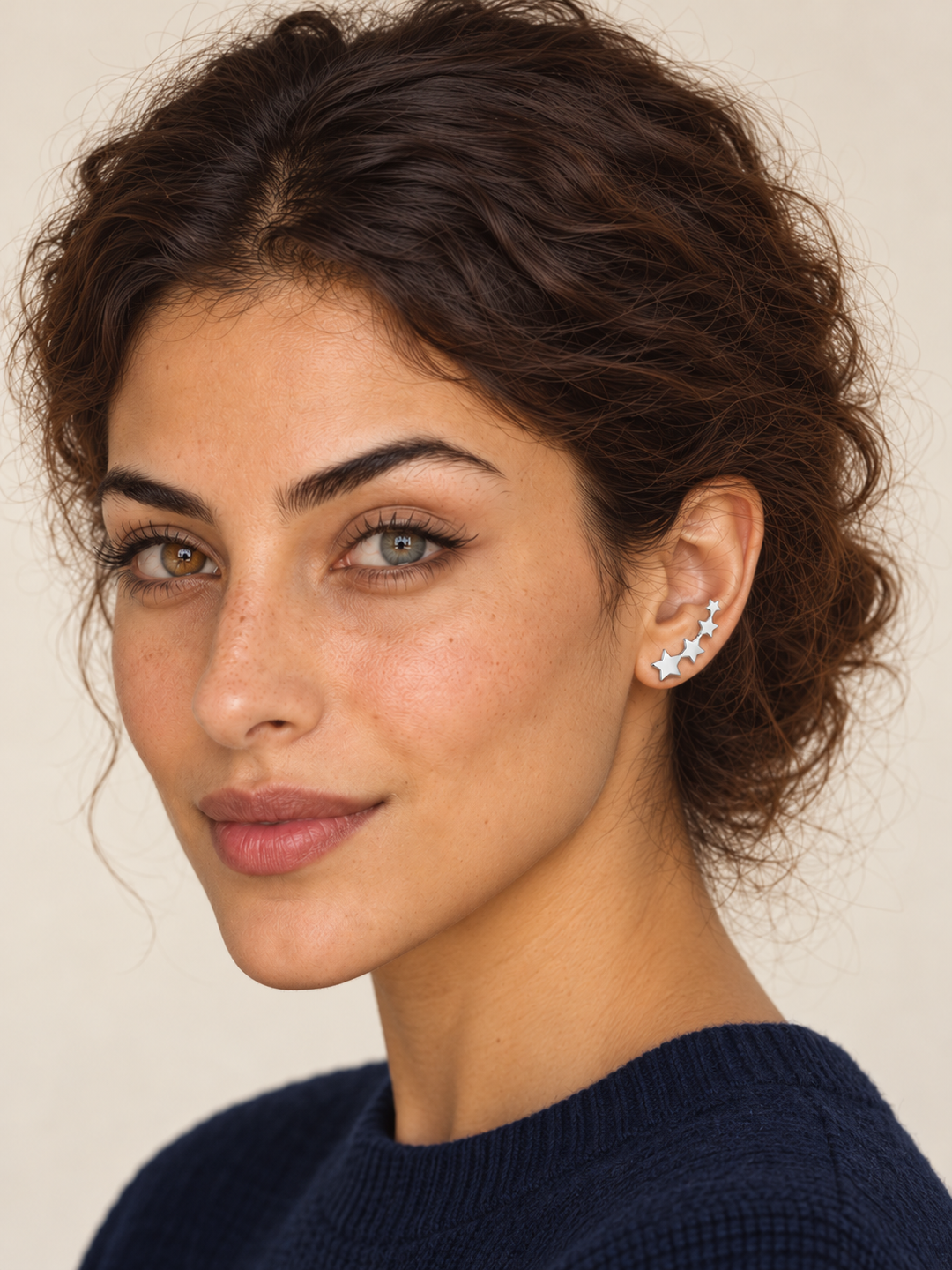 Model wearing silver Graduated Star Ear Crawler Earrings climbing the viewer-right ear