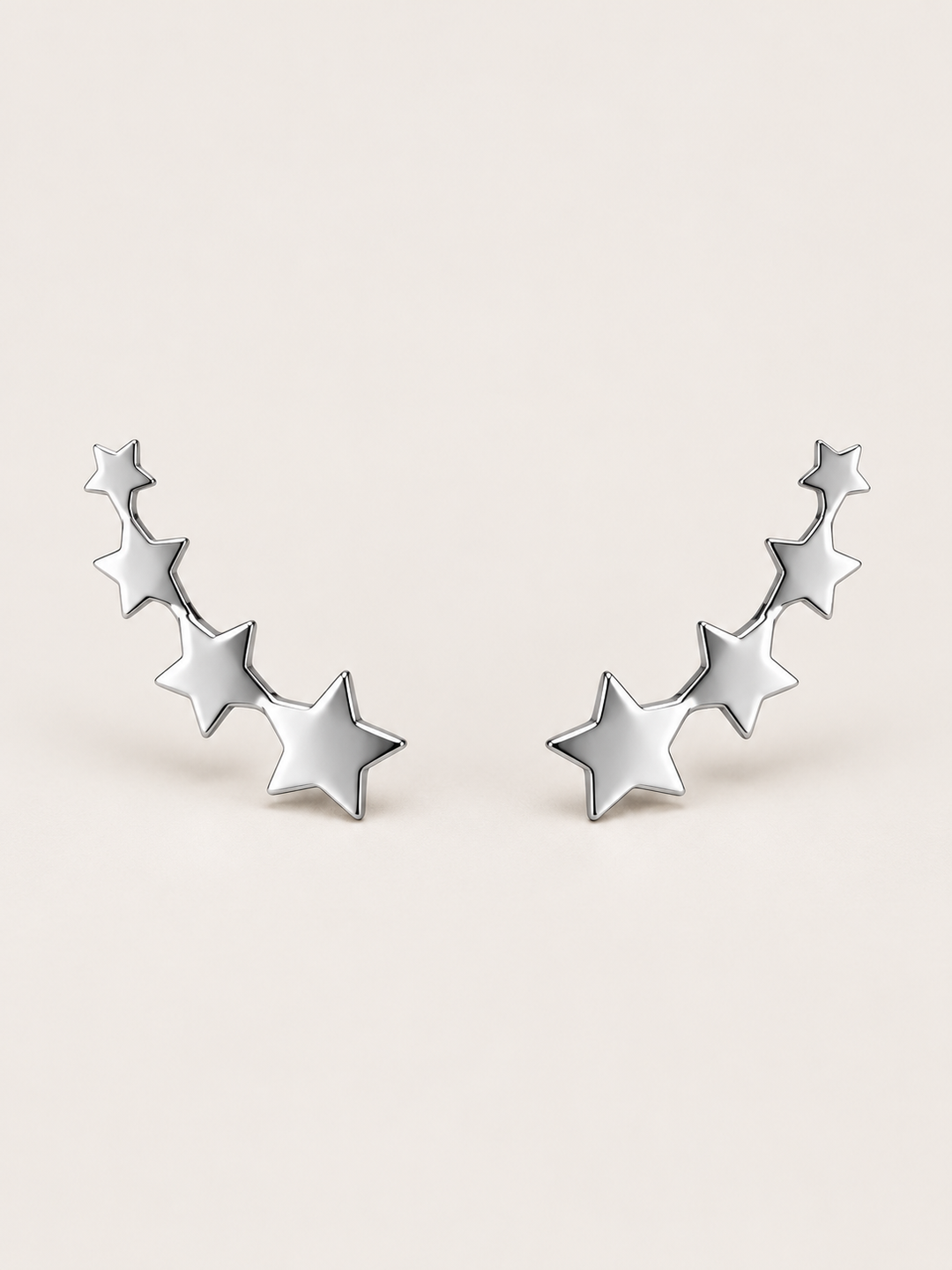 Silver Graduated Star Ear Crawler Earrings shown on a warm neutral background