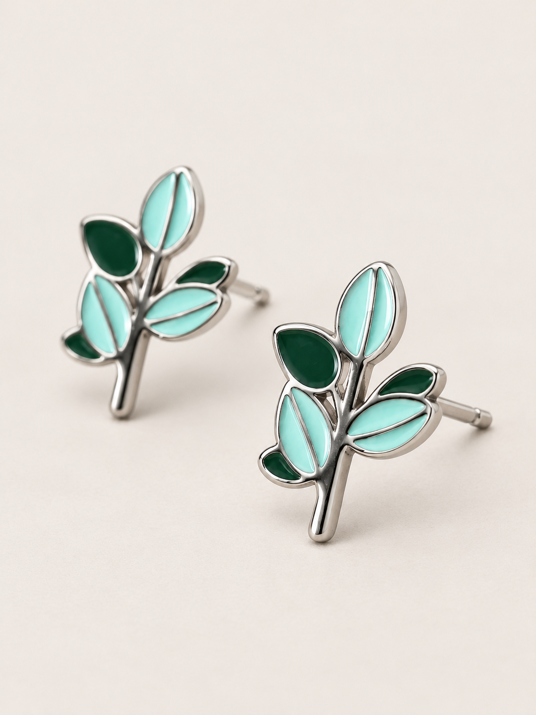 Green Leaf Stud Earrings shown angled on a warm neutral background