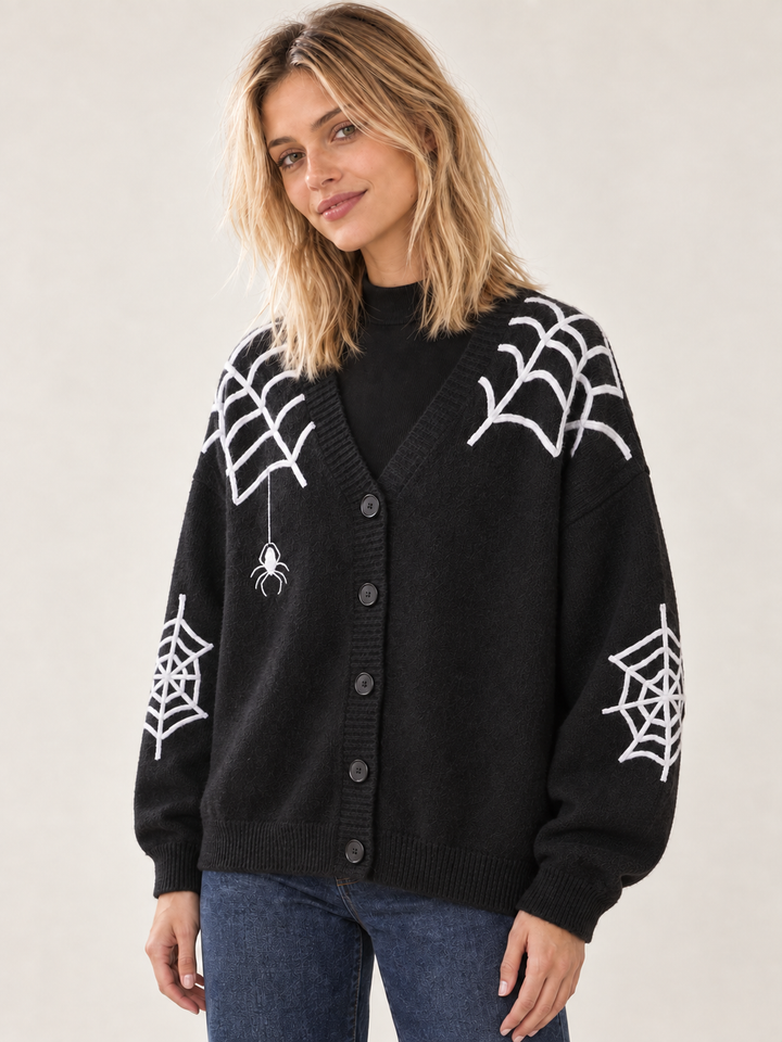 Angled view of black Halloween cardigan with white spiderwebs and spider applique