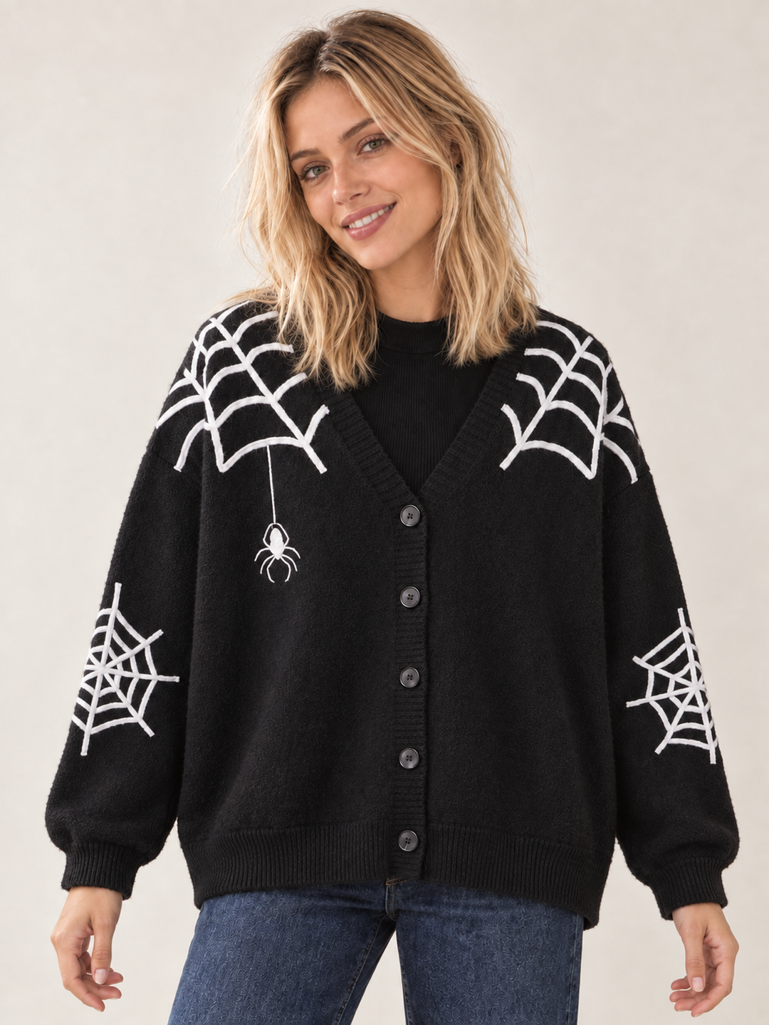 Front view of black Halloween cardigan with white spiderwebs and spider applique