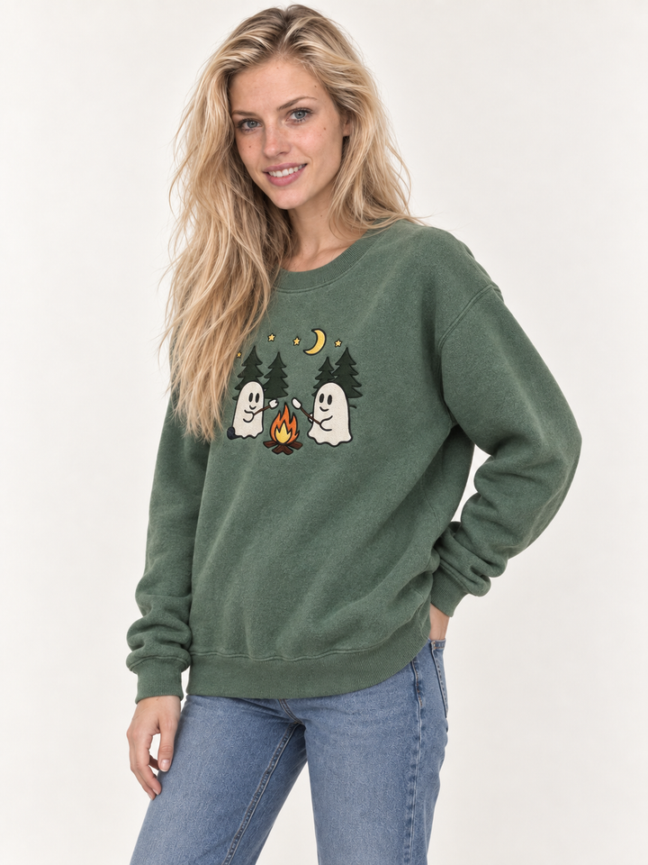 Model wearing sage green embroidered ghost campfire sweatshirt, 45-degree view