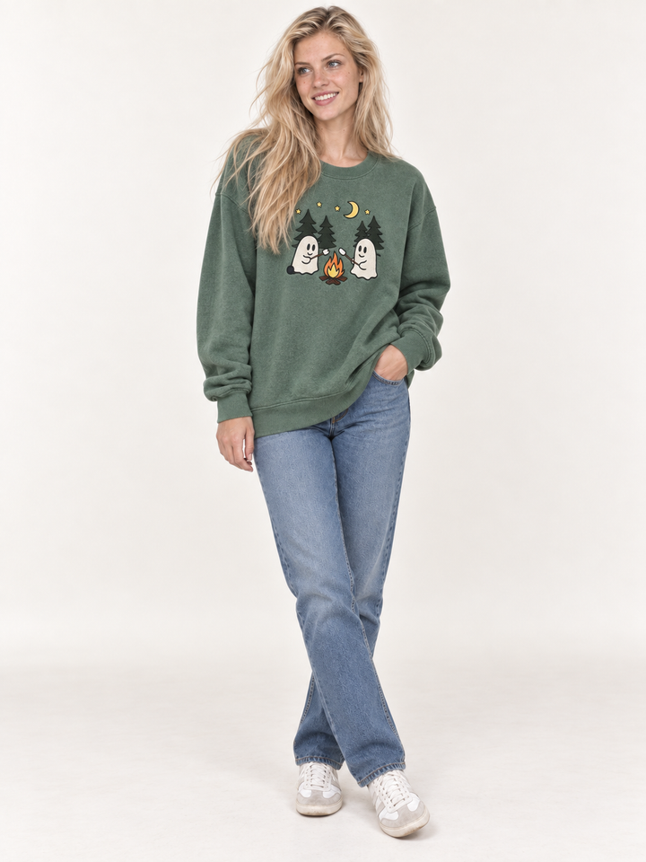 Model wearing sage green embroidered ghost campfire sweatshirt, full-body front view