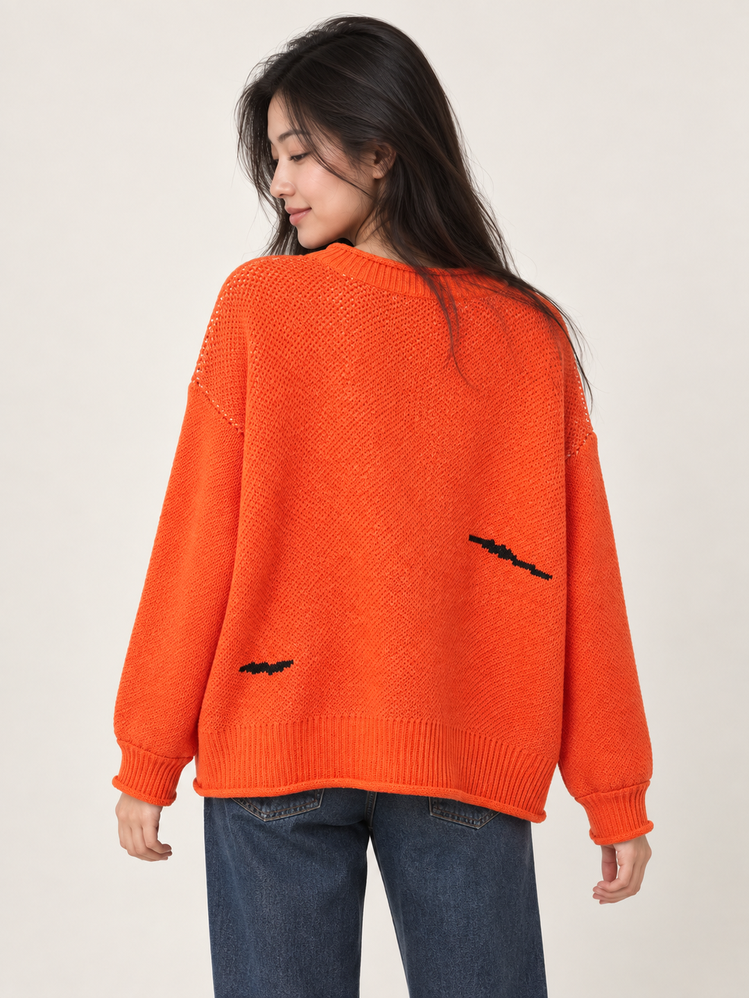 Back view of orange Halloween sweater with two black bat motifs