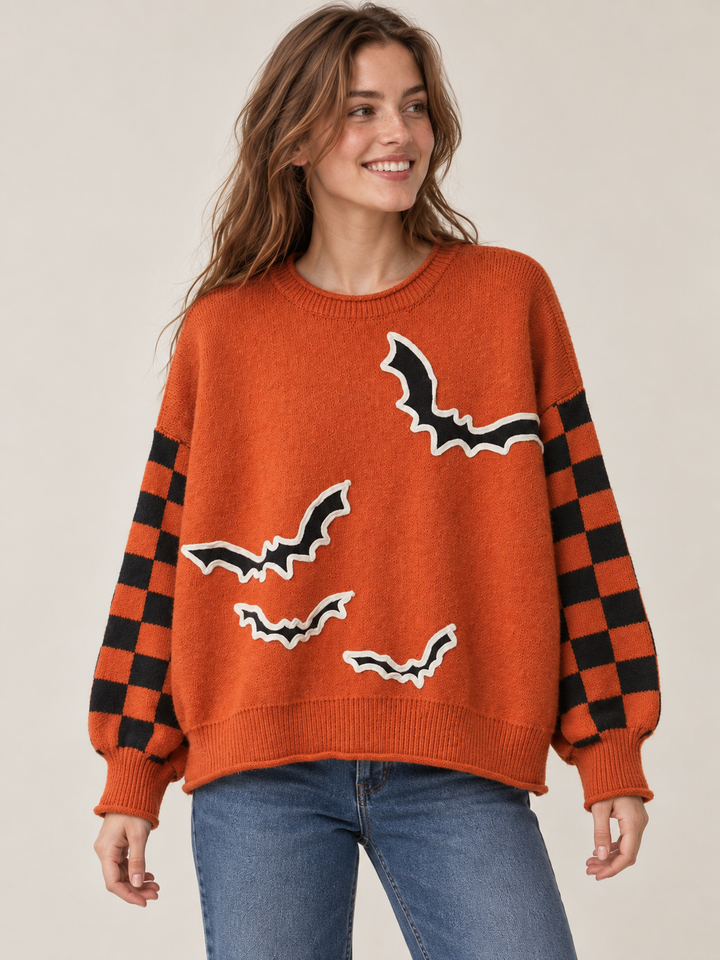 Orange bat applique sweater with checkered sleeves, front view on model