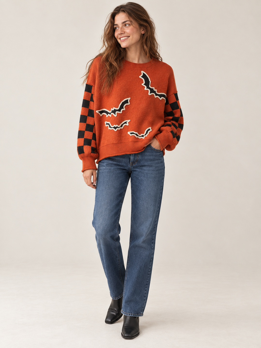 Orange bat applique sweater with straight-leg jeans, full-body front view