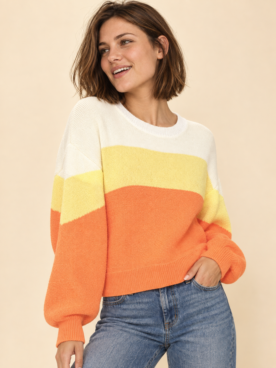 Model wearing Halloween candy corn striped sweater, three-quarter view