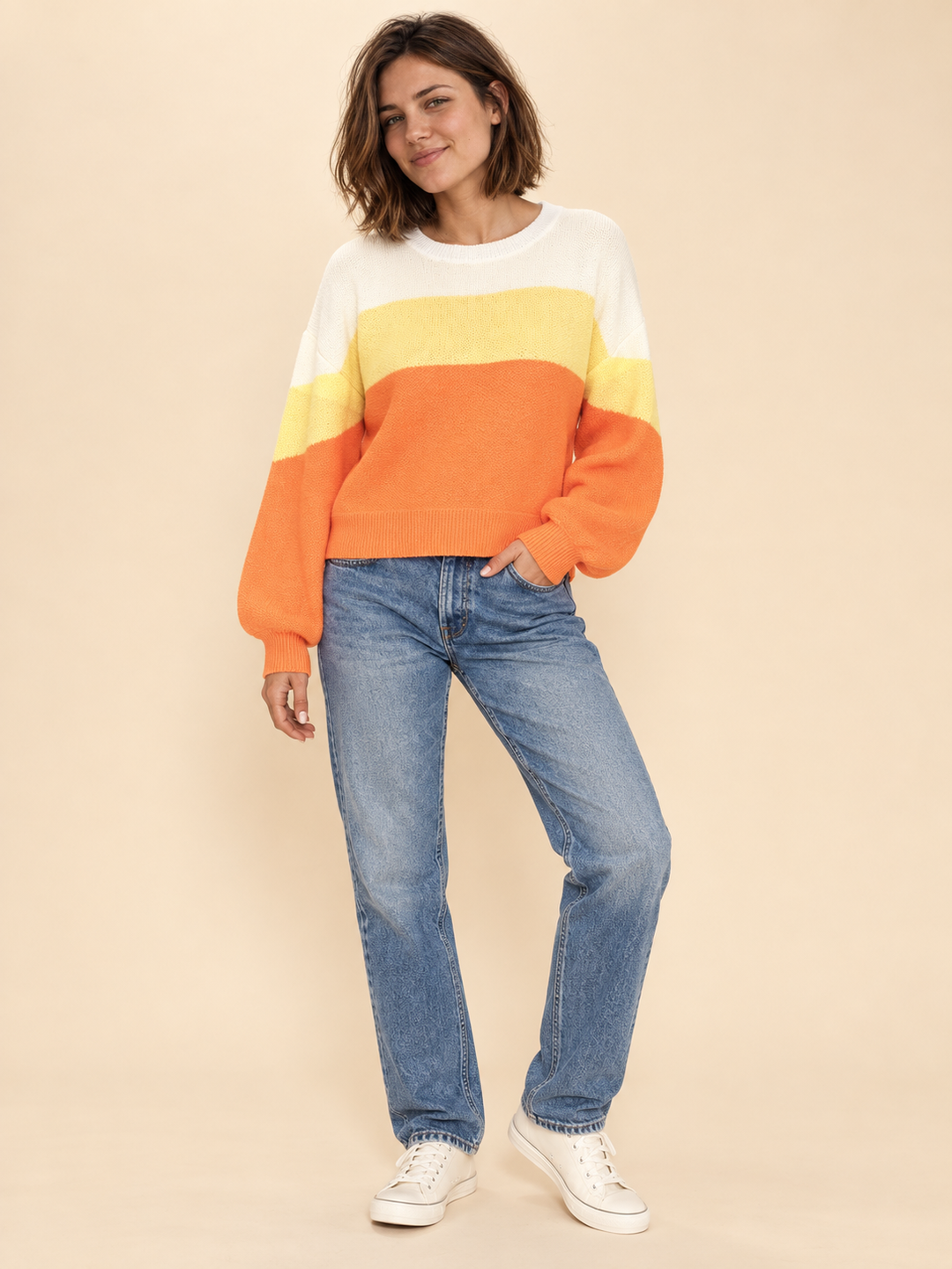 Model wearing Halloween candy corn striped sweater, full-body view