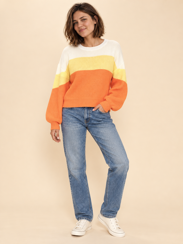 Model wearing Halloween candy corn striped sweater, full-body view