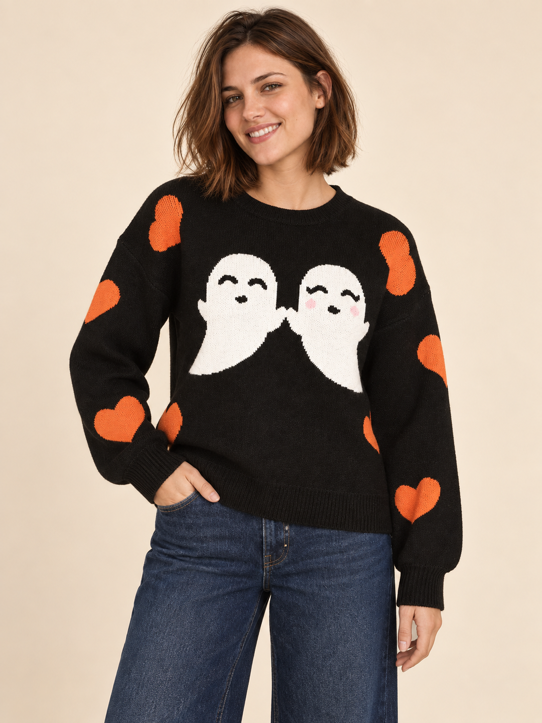 Black Halloween sweater with white ghosts and orange hearts, front view on model