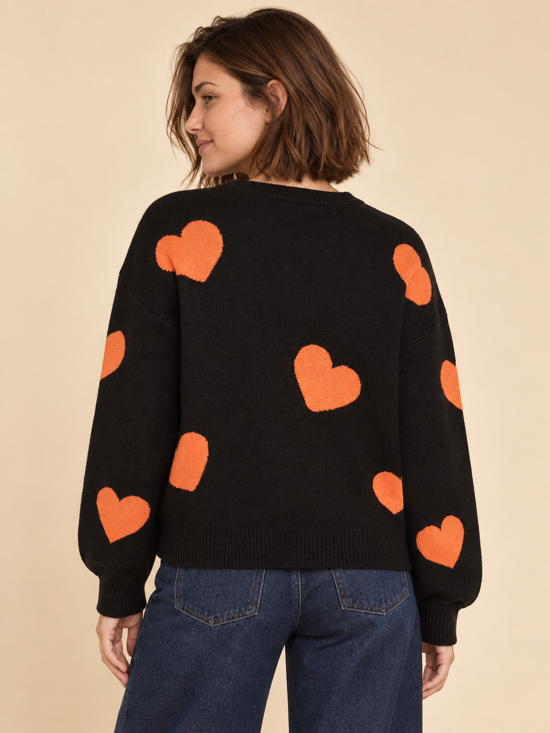 Black Halloween sweater with white ghosts and orange hearts, back view on model
