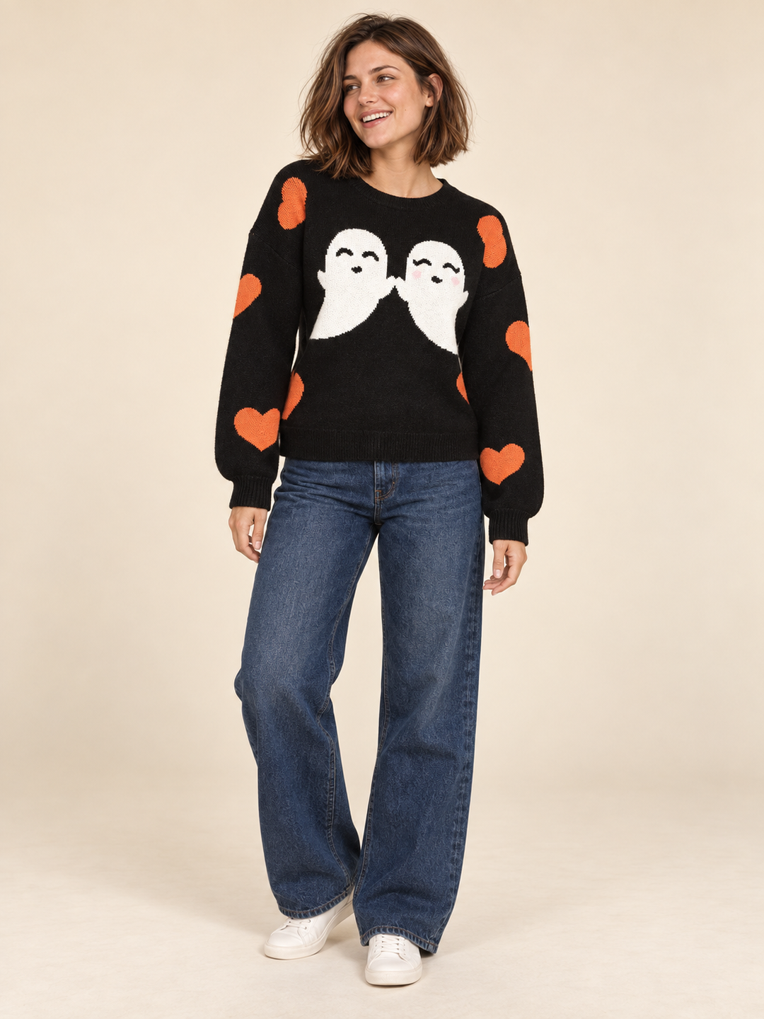 Black Halloween sweater with white ghosts and orange hearts, full-body front view on model