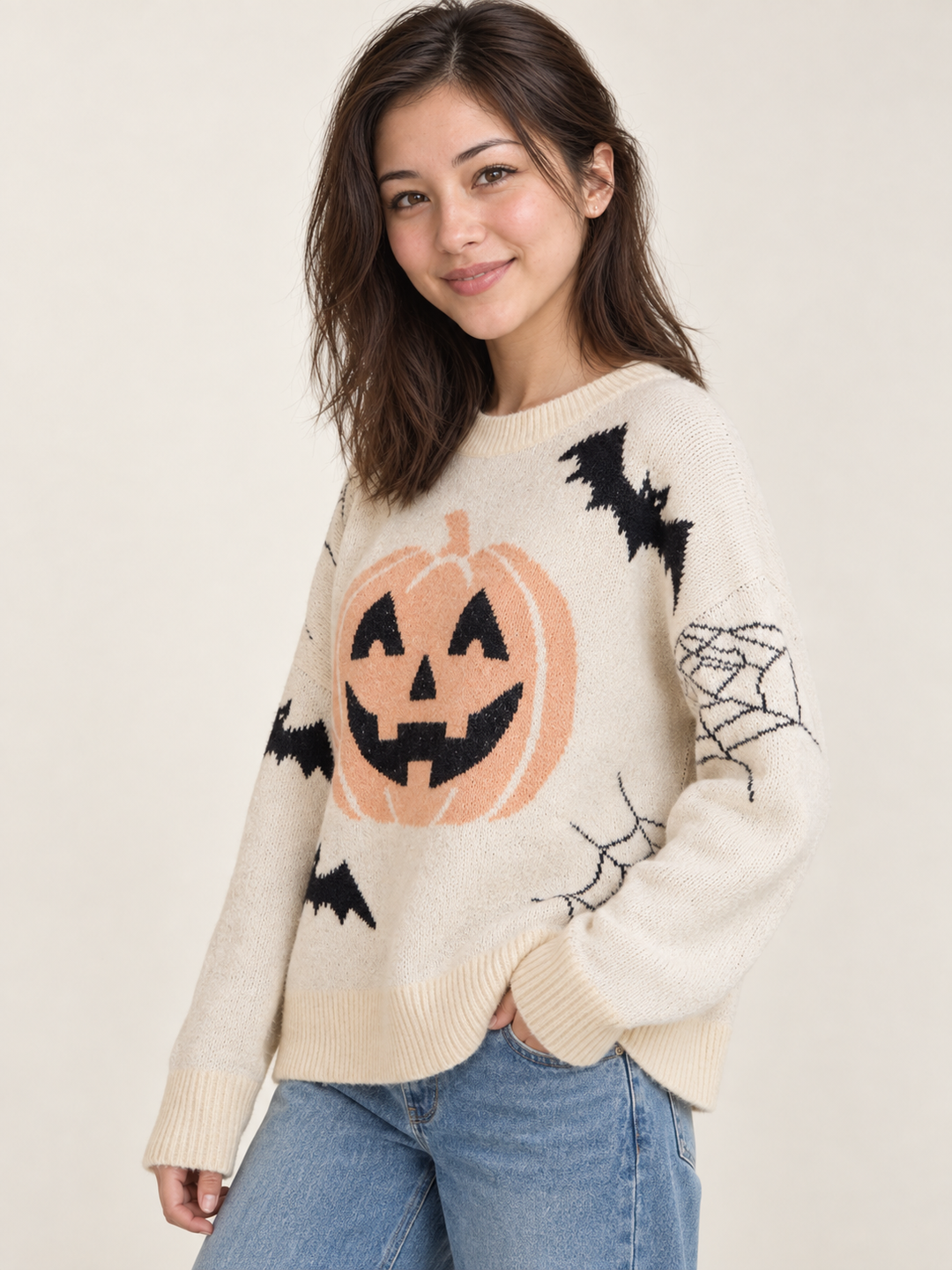 Cream pumpkin and bat Halloween sweater, 45-degree view on model